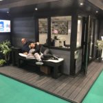 Upgraded Composite Garden Building Featured In Showroom With Staff Sitting On A Bench